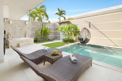 a backyard with a swimming pool and a villa at Bali Cosy Villas Seminyak in Legian