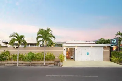 a house with a garage and palm trees at Bali Cosy Villas Seminyak in Legian