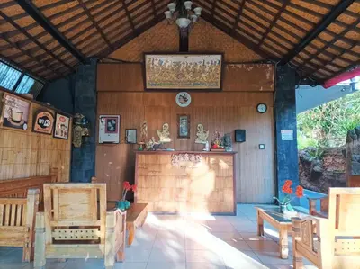 a room with wooden walls and a table and chairs at Sapta Petala Hotel in Kuta