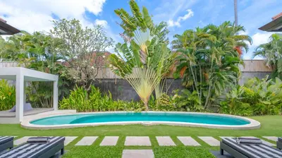 a swimming pool in a yard with trees at Villa Alice by Villa Finder in Seminyak