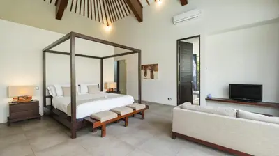 a bedroom with a bed and a couch at Villa Alice by Villa Finder in Seminyak