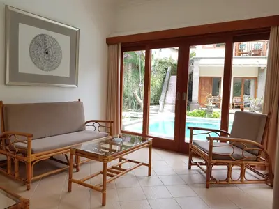 a living room with a couch and two chairs and a table at Puri Mesari Hotel in Sanur