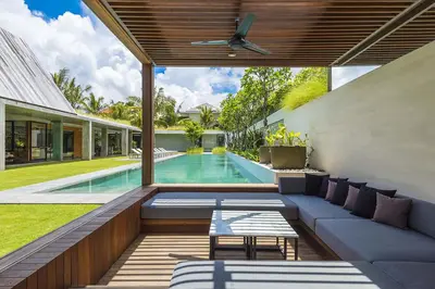 an outdoor patio with a couch and a swimming pool at Villa Keila Seminyak in Seminyak