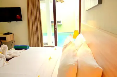 a bed with white sheets and pillows in a room at Jas Boutique Villas in Seminyak