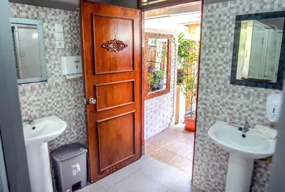 a bathroom with two sinks and a wooden door at Restu Bali Hotel in Legian