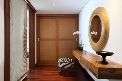 a hallway with a wooden console table and a mirror at The One Boutique Villa & Spa Seminyak in Seminyak