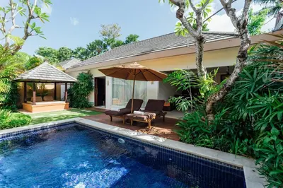 a villa with a swimming pool and a house at The Yubi Boutique Villas Seminyak in Seminyak