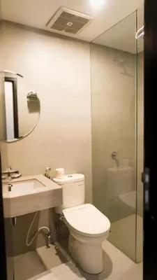 a bathroom with a toilet and a sink and a shower at Grand Kuta Hotel and Residence in Legian