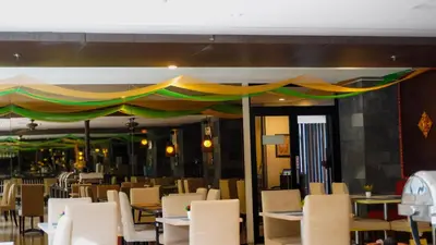 a dining room with tables and chairs and a canopy at Grand Kuta Hotel and Residence in Legian