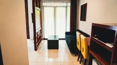 a living room with a couch and a table at Grand Kuta Hotel and Residence in Legian