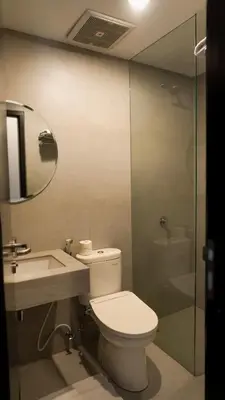 a bathroom with a toilet and a sink and a shower at Grand Kuta Hotel and Residence in Legian