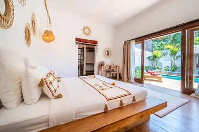 a bedroom with a bed and a large window at Villa Makasih by Villa Finder in Seminyak
