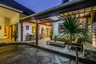 a patio with a couch and a potted plant at Villa Mira in Seminyak
