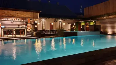 a swimming pool in a hotel at night at The Banyumas Villa in Denpasar