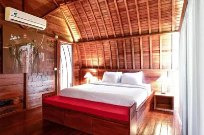 a bed with a red bench in a room at The Lumbung Wood Villa in Seminyak
