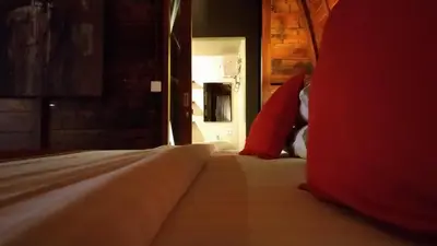a bedroom with a bed with a red pillow at The Lumbung Wood Villa in Seminyak