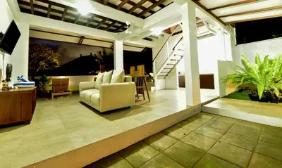 a living room with a couch and a chair at The Lumbung Wood Villa in Seminyak