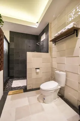 a bathroom with a toilet and a shower at Sunset Paradise at Temple Hill Jimbaran in Jimbaran