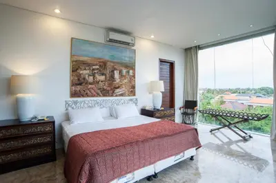 a bedroom with a bed and a painting on the wall at Bali Mystique Hotel & Apartment in Seminyak