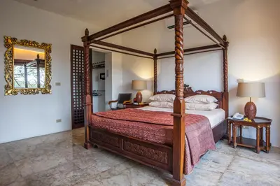 a bedroom with a canopy bed and a mirror at Bali Mystique Hotel & Apartment in Seminyak