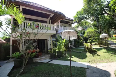 a house with a garden in front of it at Bali Mystique Hotel & Apartment in Seminyak