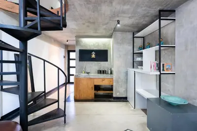 a loft conversion with a staircase and a bathroom at Balissimo Suites Seminyak by Betterplace in Seminyak