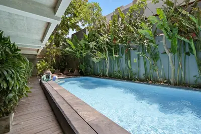 a swimming pool in a backyard with plants at Balissimo Suites Seminyak by Betterplace in Seminyak