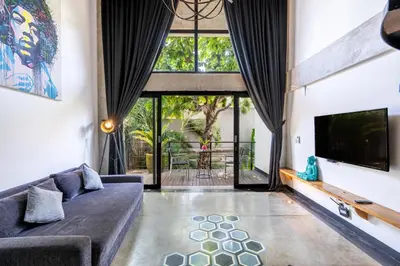 a living room with a couch and a tv at Balissimo Suites Seminyak by Betterplace in Seminyak