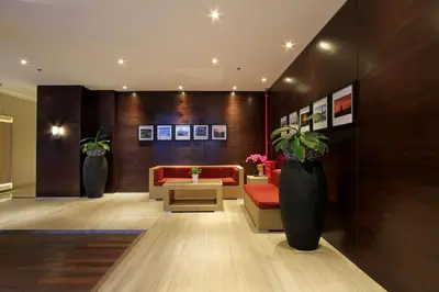 a lobby with a couch and a table and vases at Ohana Hotel Kuta in Kuta