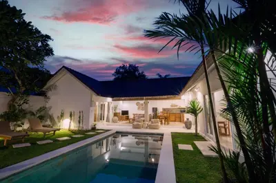 a villa with a swimming pool at night at Villa Pagu in Seminyak
