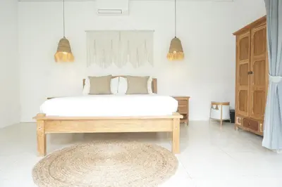 a bedroom with a bed and a rug at Villa Pagu in Seminyak