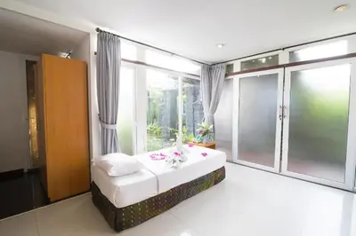 a bedroom with a bed and a large window at Aqua Bali Villa in Canggu