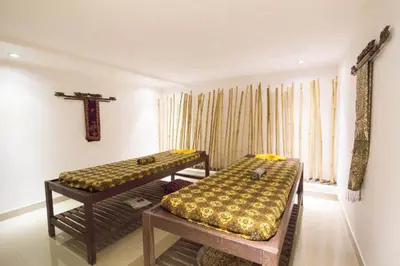 two beds in a room with a cross on the wall at Aqua Bali Villa in Canggu