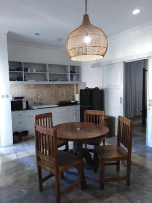 a kitchen with a table and chairs and aendant light at Bali Court Hotel & Apartment in Legian