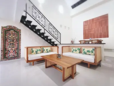 a living room with two benches and a table at Kumpul Kumpul Villa Seminyak - CHSE Certified in Seminyak
