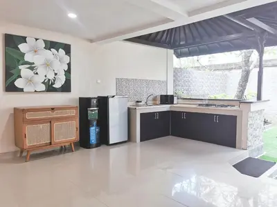 a kitchen with a refrigerator and a counter top at Kumpul Kumpul Villa Seminyak - CHSE Certified in Seminyak