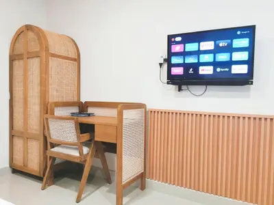 a table with two chairs and a television on a wall at Kumpul Kumpul Villa Seminyak - CHSE Certified in Seminyak