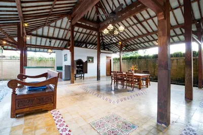 a pavilion with a table and chairs and a fireplace at Bali Royal Heritage Villas in Seminyak