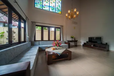 a living room with a couch and a table with flowers at Casa Priya Seminyak in Kerobokan