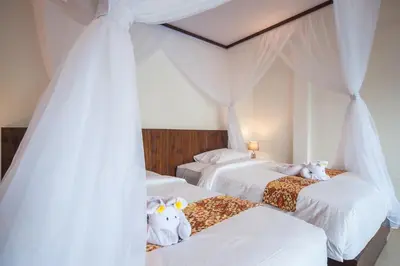 a bedroom with three beds with stuffed animals on them at Casa Priya Seminyak in Kerobokan