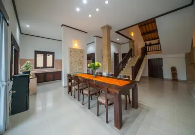 a dining room with a table and some stairs at Casa Priya Seminyak in Kerobokan