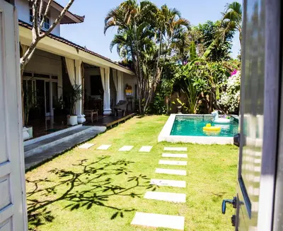 a backyard with a swimming pool and a house at Villa Jalun in Seminyak