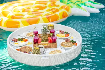 a table of food on a raft in the water at Unicorn Shelter Villa in Seminyak