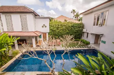 a villa with a swimming pool in front of a house at Abian Biu Mansion in Canggu