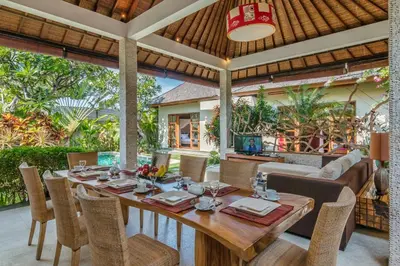 a dining room with a wooden table and chairs at Villa Essence in Seminyak