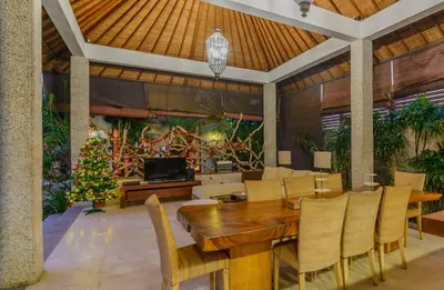 a dining room with a table and chairs and a christmas tree at Villa Essence in Seminyak