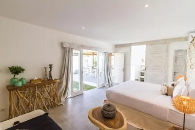 a bedroom with a large bed and a table at Villa Opaline by Alfred in Bali in Seminyak