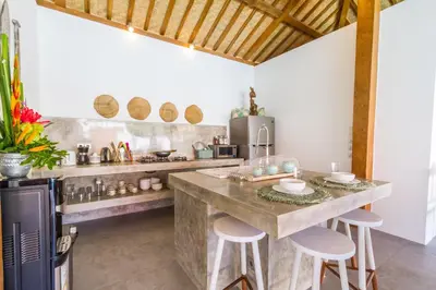 a kitchen with a large counter with stools in it at Villa Opaline by Alfred in Bali in Seminyak