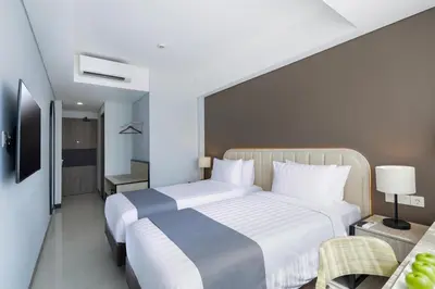 a bedroom with a large bed with white sheets at Royal Regantris Kuta in Kuta
