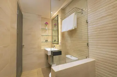 a bathroom with a sink and a toilet and a mirror at Royal Regantris Kuta in Kuta
